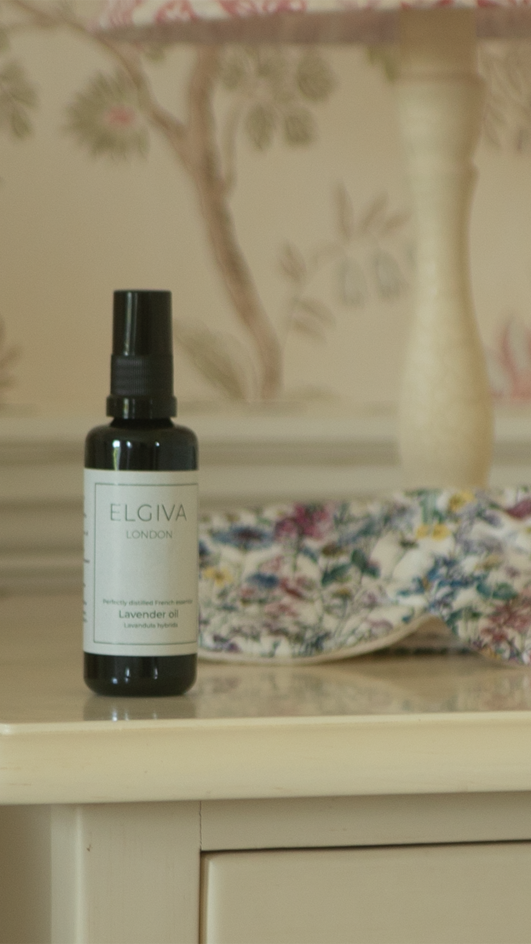 Elgiva London 50ml lavender oil bottle styled on a bedside table with a sleep eye mask, tall crop